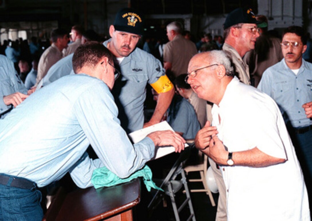 An evacuee from Freetown, Sierra Leone, is processed after arriving onboard the USS Kearsarge (LHD 3), on May 30, 1997, during Operation Noble Obelisk. Over 900 people from 40 different countries have been evacuated. 