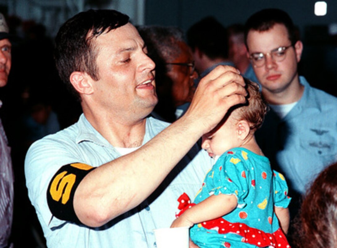 Petty Officer 2nd Class Racey C. Swing comforts an infant evacuee from Freetown, Sierra Leone, after arriving onboard the USS Kearsarge (LHD 3), on May 30, 1997, during Operation Noble Obelisk. Over 900 people from 40 different countries have been evacuated. Swing is a Navy Aviation Boatswain Mate (Fuels). 