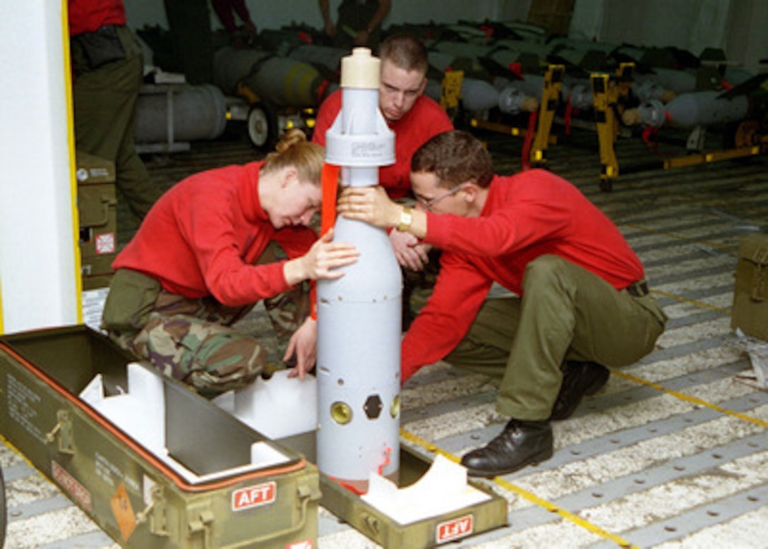 Petty Officer 2nd Class Kathy Higingbotham (left), Airman Apprentice Jon Mitchell (center), and Aviation Ordnanceman Thomas Moore (right) inspect the guidance system assembly on a laser guided GBU-16 bomb on board the aircraft carrier USS Nimitz (CVN 68) on Nov. 10, 1997. The USS Nimitz (CVN 68) battle group is operating in the Persian Gulf in support of the U.S. and coalition enforcement of the no-fly-zone over Southern Iraq. All three are aviation ordnancemen assigned to the weapons department aboard the USS Nimitz. Higingbotham is from Addy, Wash.; Mitchell is from Lakeland, Fla.; and Moore is from San Diego, Calif. 