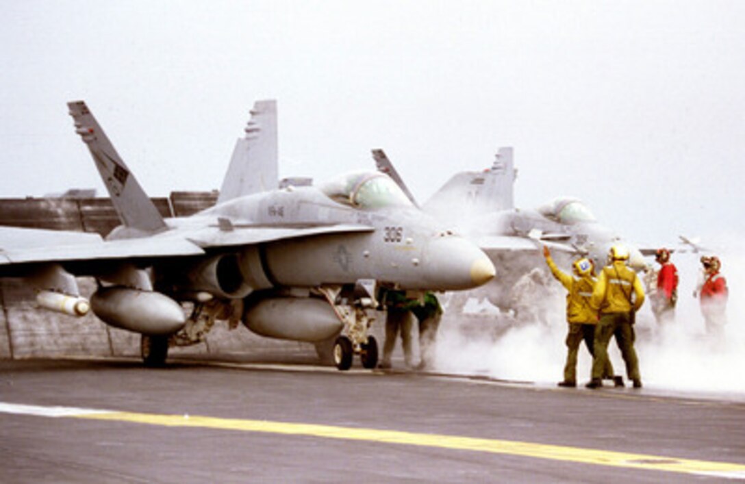 Flight deck personnel on board the aircraft carrier USS Nimitz (CVN 68) prepare an F/A-18 Hornet for launch during flight operations in the Persian Gulf on Nov. 10, 1997. The Nimitz and embarked Carrier Air Wing 9 are operating in the Persian Gulf in support of the U.S. and coalition enforcement of the no-fly-zone over Southern Iraq. The Hornet is assigned to Strike Fighter Squadron 146, Naval Air Station Lemoore, Calif. 