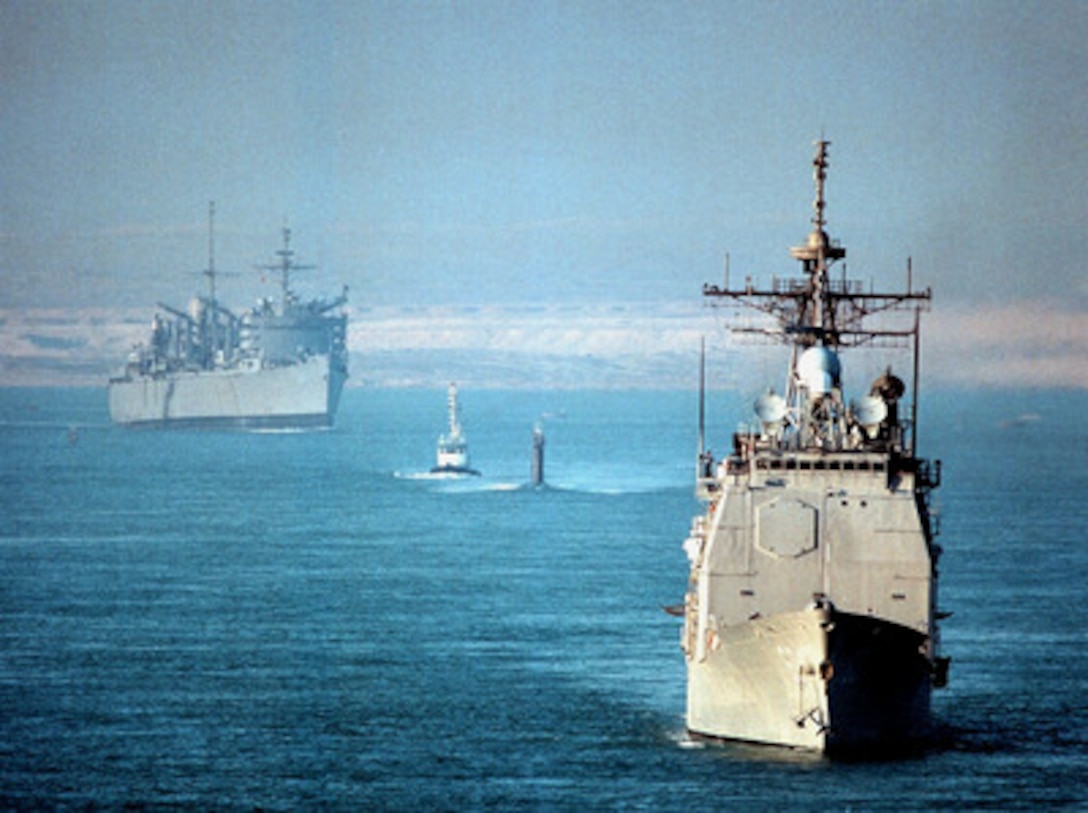 The USS Normandy (CG 60) (right), the fast attack submarine USS Annapolis (SSN 760) (center), and the fast combat support ship USS Seattle (AOE 3) (left) transit the Suez Canal on Nov. 16, 1997, as they head from the Mediterranean Sea to the Persian Gulf. The three U.S. ships are part of the aircraft carrier USS George Washington (CVN 73) battle group which has been ordered to the Persian Gulf to join the aircraft carrier USS Nimitz (CVN 68) battle group already on station. The two battle groups will be operating in the Persian Gulf in support of Operation Southern Watch which is the U.S. and coalition enforcement of the no-fly-zone over Southern Iraq. 