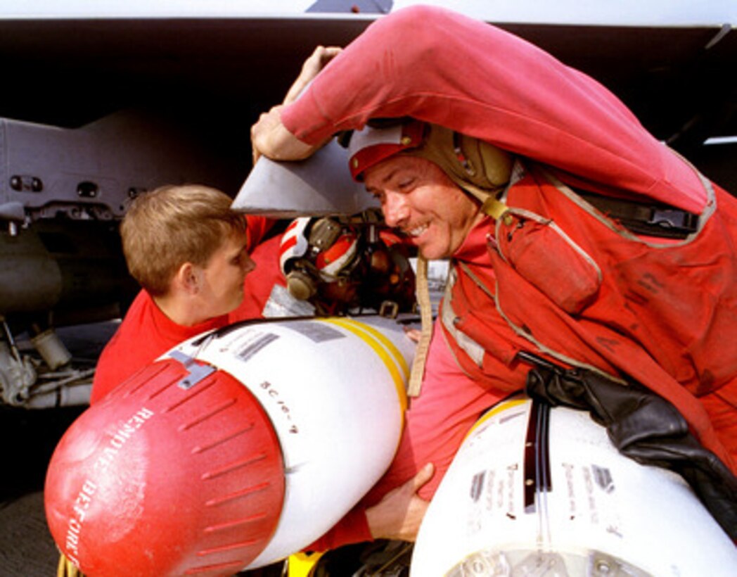 Petty Officer 3rd Class Normand E. LaFleur (right) provides a little more muscle while loading a cluster bomb on the wing of an F/A-18C Hornet on the flight deck of the aircraft carrier USS Nimitz (CVN 68) on Nov. 17, 1997. The Nimitz and embarked Carrier Air Wing 9 are operating in the Persian Gulf in support of Operation Southern Watch which is the U.S. and coalition enforcement of the no-fly-zone over Southern Iraq. LaFleur, from Mesa, Ariz., is a Navy aviation ordnanceman assigned to Strike Fighter Squadron 146. 