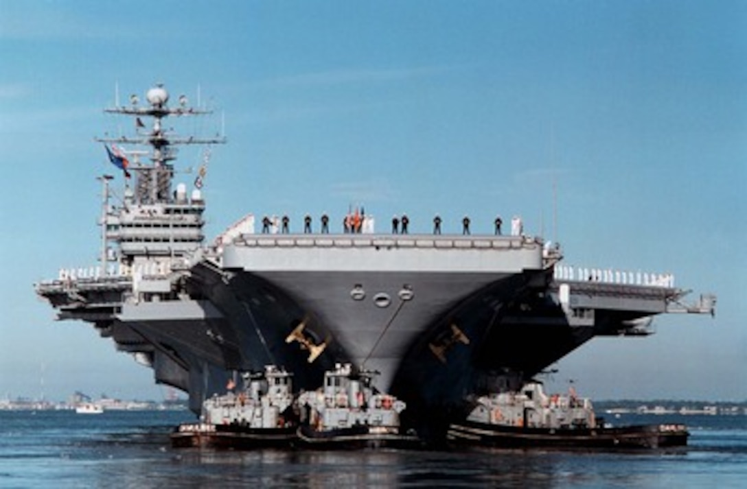 Sailors and Marines man the rail as three harbor tugs push the aircraft carrier USS George Washington (CVN 73) away from Pier 11 at Norfolk Naval Base on Oct. 3, 1997, for a scheduled six-month deployment. The George Washington will relieve the USS John F. Kennedy (CV 67) to conduct operations in the Mediterranean Sea. 