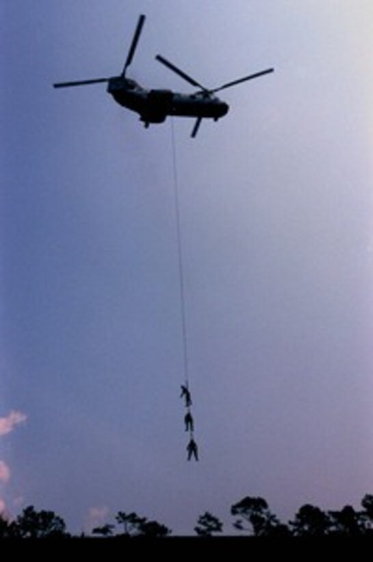 U.S. Marines dangle from a CH-46 Sea Knight helicopter as they practice Special Purpose Insertion and Extraction, or SPIE, rigging at Camp Lejeune, N.C., on Sept. 11, 1997. The Marines, from Battalion Landing Team 3/2, are honing their skills in preparation for their deployment with the 26th Marine Expeditionary Unit in February of 1998. 