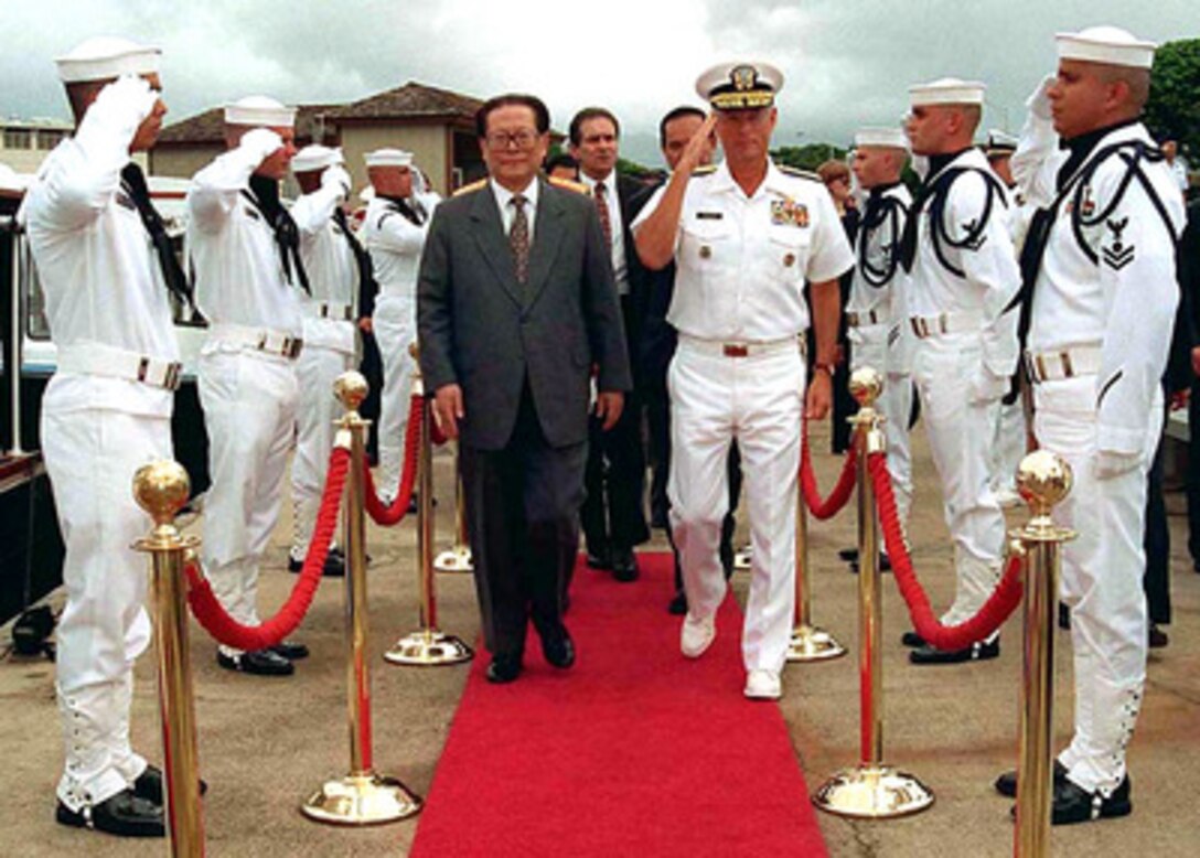Commander in Chief, U.S. Pacific Command Adm. Joseph W. Prueher (right), U.S. Navy, escorts Chinese President Jiang Zemin (left) through the traditional Navy sideboys before boarding a small boat for a tour of Pearl Harbor, Hawaii, on Oct. 26, 1997. 