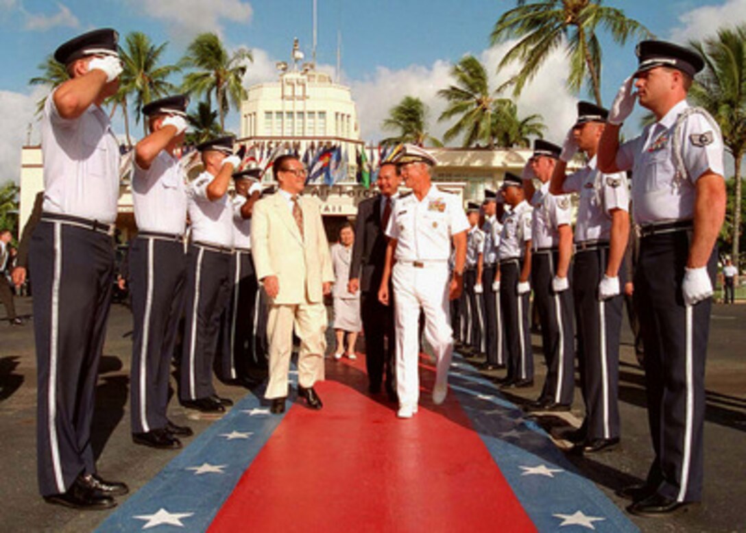 Commander in Chief, U.S. Pacific Command Adm. Joseph W. Prueher (right), U.S. Navy, escorts Chinese President Jiang Zemin (left) through the through an Air Force Honor Guard to his waiting airplane at Hickam Air Force Base, Hawaii, on Oct. 27, 1997. 
