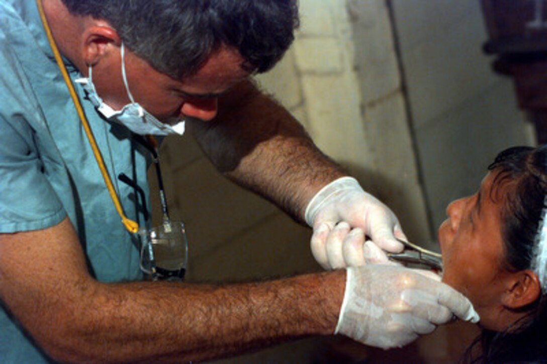 Maj. Michael Child extracts the wisdom teeth of a young girl during a medical civil assistance program in Guyana on Sept. 3, 1997. The program is part of the joint-combined humanitarian Exercise New Horizon Guyana 1997. U.S. forces, the Guyana Defense Force and local community leaders are working together to accomplish engineer construction and medical projects. Child is a U.S. Army National Guard dentist. 