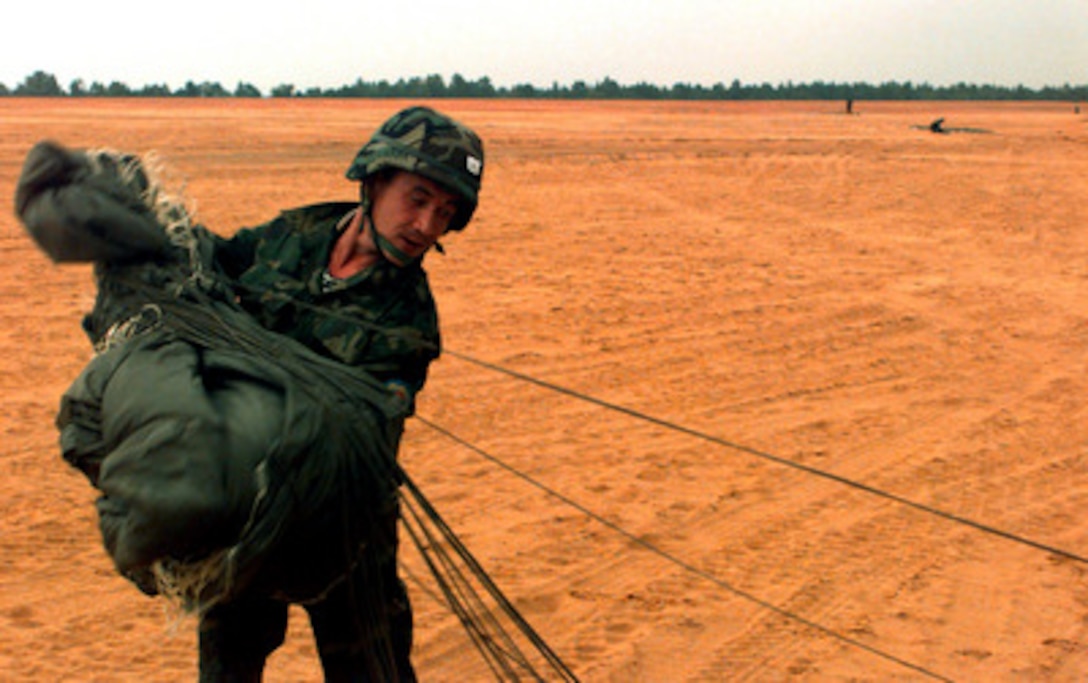 A soldier from Kyrgyzstan stows his parachute after his jump, along with soldiers of the U.S. Army's 82nd Airborne Division, from a U.S. Air Force C-17 Globemaster III at Fort Bragg, N.C., on Sept. 8, 1997. The soldiers will take part in the longest distance airborne operation in history during Exercise Central Asian Battalion '97. Exercise Central Asian Battalion '97 involves more than 900 military personnel from Georgia, Kazakhstan, Kyrgyzstan, Latvia, Russia, Ukraine and Uzbekistan who are training with over 500 U.S. military troops to hone their skills in peacekeeping and humanitarian assistance. The exercise will enhance regional cooperation and increase interoperability training among NATO and Partnership for Peace nations. The exercise is being held in Shymkent, Kazakhstan, and Chirchik, Uzbekistan. 