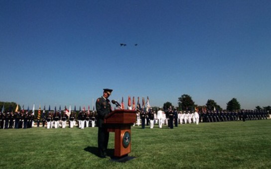 U.S. Navy, Marine Corps and Air Force jets fly over the Pentagon parade field in the missing man formation as Brig. Gen. Gaylord Gunhus, U.S. Army Chaplain Corps, offers the benediction during the National POW/MIA Recognition Day ceremony on Sept. 19, 1997.