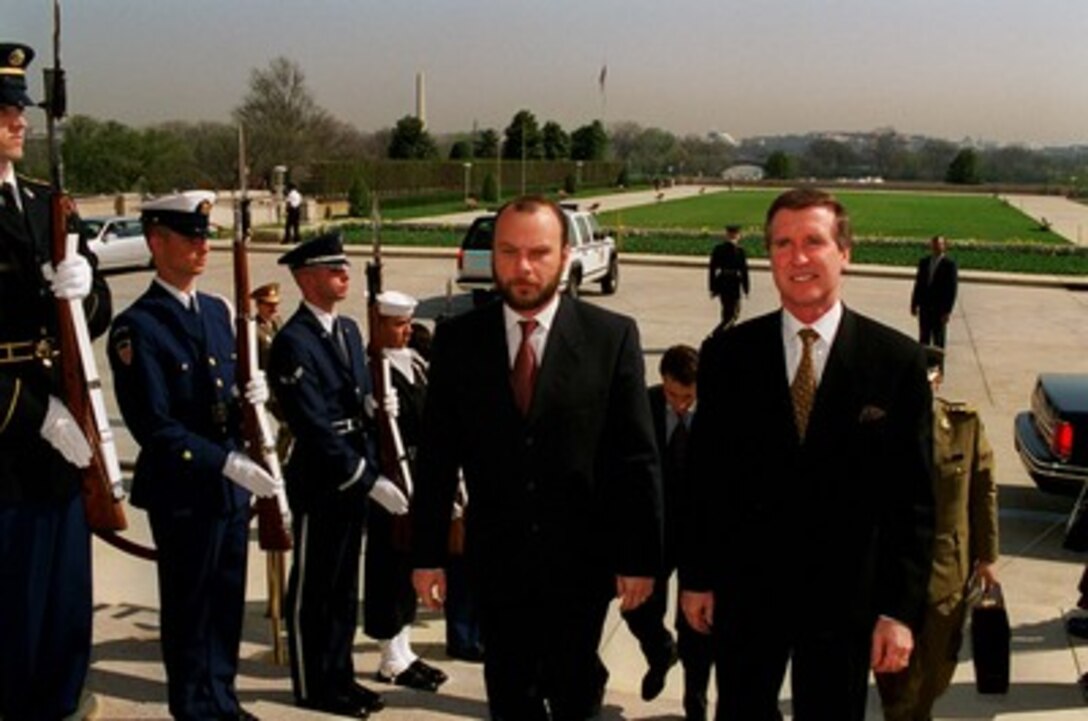 Secretary of Defense William S. Cohen (right) escorts Minister of Defense Constantin D. Ionescu (left), of Romania, through an armed forces honor cordon into the Pentagon on March 30, 1998. 