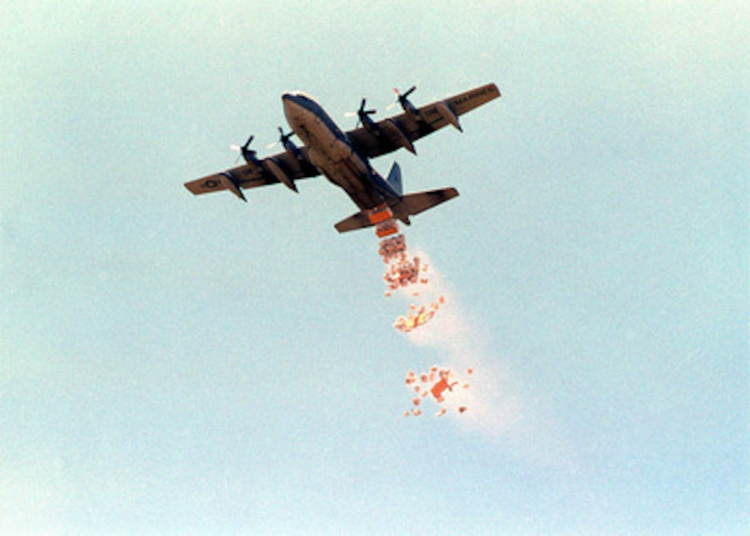Sacks of corn come hurtling to the earth as a U.S. Marine Corps C-130 Hercules drops a load of World Food Program corn on the drop zone outside the village of Madogashi, Kenya, on March 4, 1998. U.S. Central Command forces are conducting Operation Noble Response to provide disaster relief assistance to flood victims in Kenya. Central Command is working with the United States Agency for International Development and the World Food Program to deliver the aid which is being provided at the request of the government of Kenya. 
