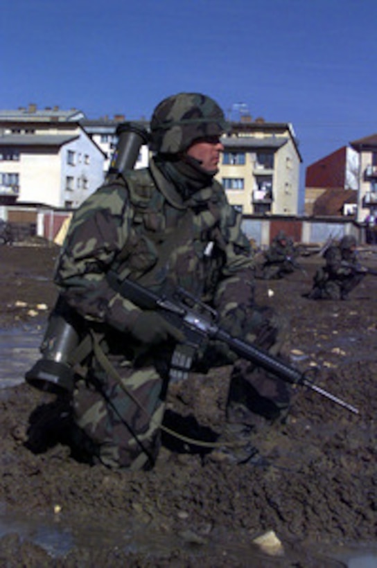 Lance Cpl. Scott Fleckenstein and his fellow Marines of the 26th Marine Expeditionary Unit establish a security perimeter in a muddy soccer field at Sokalac, Bosnia and Herzegovina, on March 28, 1998. The Marines, deployed from Camp Lejeune, N.C., are taking part in Exercise Dynamic Response 98. The exercise is designed to test the capabilities of the NATO's Strategic Reserve Force in support of the in-theater Stabilization Force. 
