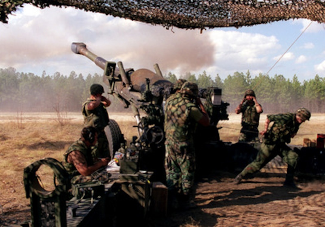 U.S. Marines from the 5th Battalion, 10th Marine Regiment grimace as they fire an M-198 155 mm howitzer at Fort Bragg, N.C., during the Supporting Arms Training Exercise on April 1, 1998. 