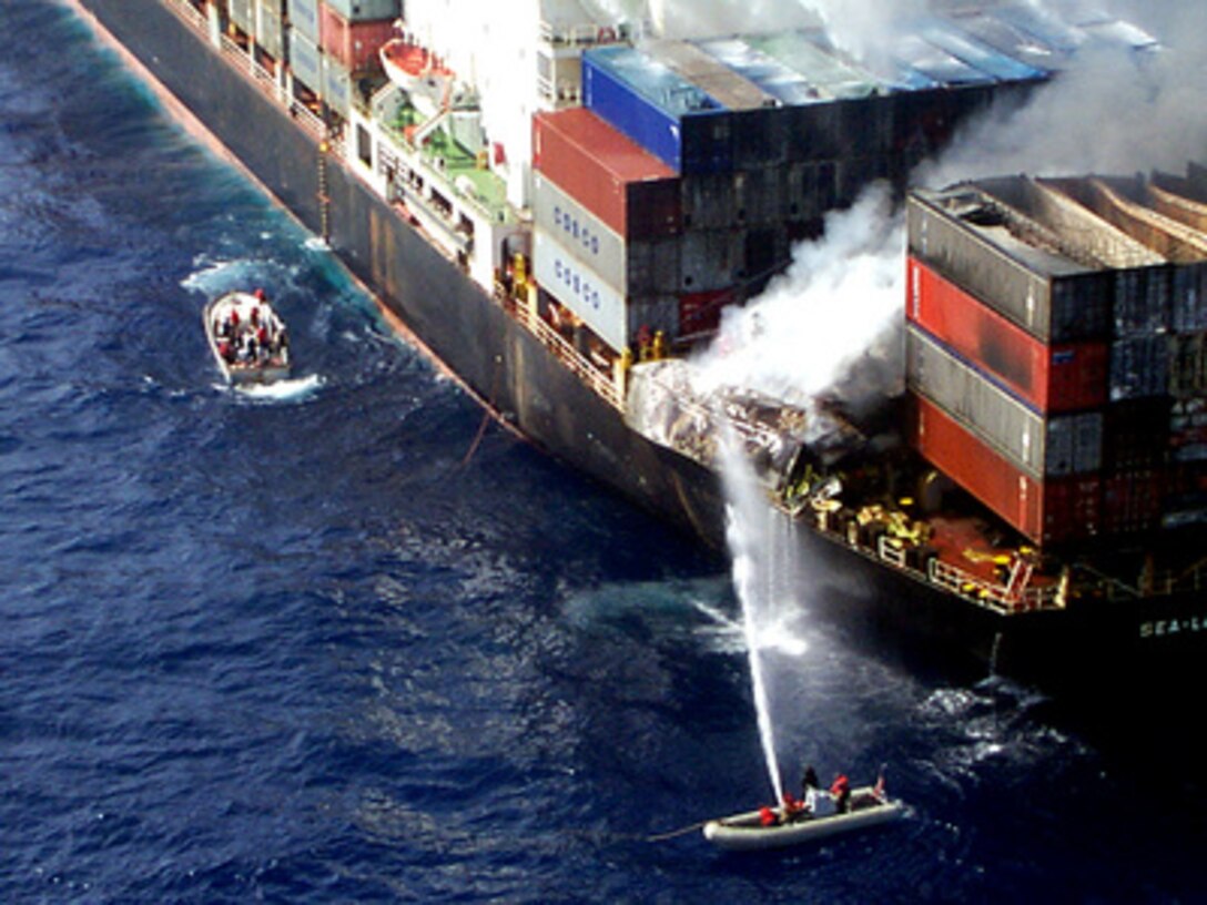Sailors from the U.S. Navy amphibious assault ship USS Wasp (LHD 1) aim a fire hose at burning cargo containers aboard the merchant cargo vessel Sea Land Mariner in the Mediterranean Sea on April 18, 1998. Search and rescue crew members, helicopters and an 18-person fire-fighting team from the Wasp responded to an emergency distress call from the merchant vessel in the Mediterranean Sea, approximately 85 miles west of Crete. A U.S. Navy CH-46 Sea Knight helicopter air-lifted two of the merchant vessel crew members to the Wasp for medical treatment of injuries caused by the initial explosion. 