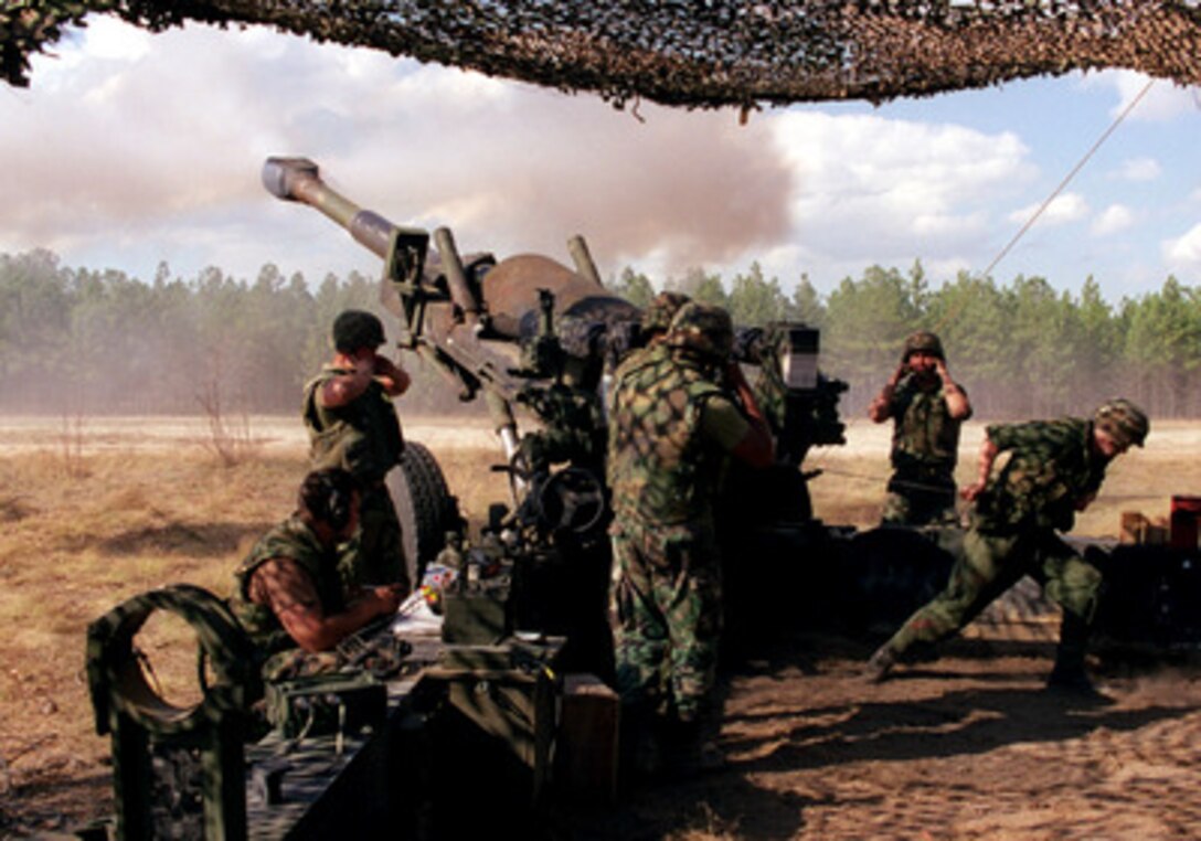 U.S. Marines from the 5th Battalion, 10th Marine Regiment grimace as they fire an M-198 155 mm howitzer at Fort Bragg, N.C., during the Supporting Arms Training Exercise on April 1, 1998. 