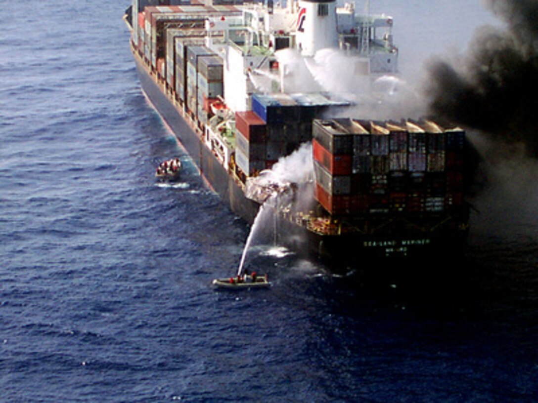 Sailors from the U.S. Navy amphibious assault ship USS Wasp (LHD 1) aim a fire hose at burning cargo containers aboard the merchant cargo vessel Sea Land Mariner in the Mediterranean Sea on April 18, 1998. Search and rescue crew members, helicopters and an 18-person fire-fighting team from the Wasp responded to an emergency distress call from the merchant vessel in the Mediterranean Sea, approximately 85 miles west of Crete. A U.S. Navy CH-46 Sea Knight helicopter air-lifted two of the merchant vessel crew members to the Wasp for medical treatment of injuries caused by the initial explosion. 