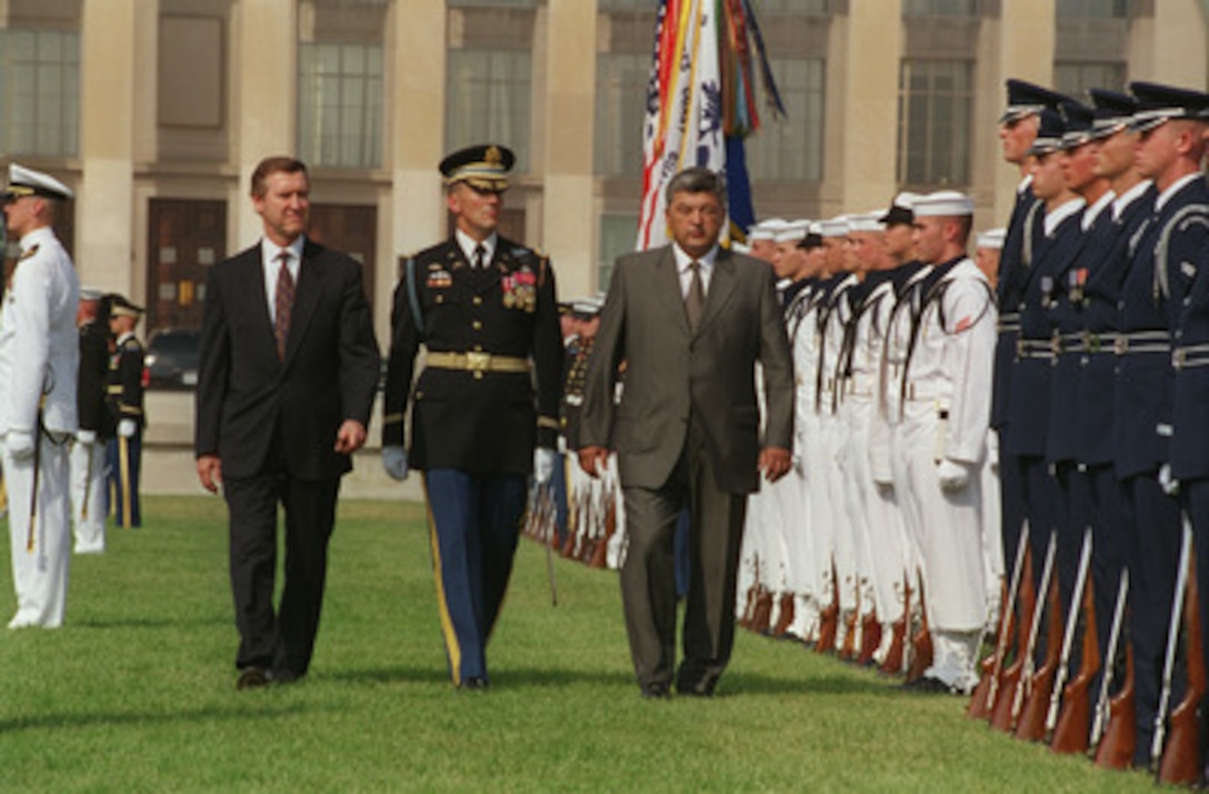 Minister of Defense Col.-Gen. Mukhtar Altynbayev (right) of the Republic of Kazakhstan and Secretary of Defense William S. Cohen (left) are escorted by Commander of Troops Col. Gregory Gardner (center), U.S. Army, as they inspect the joint honor guard during an arrival ceremony for Altynbayev at the Pentagon on July 20, 1998. Cohen and Altynbayev will meet to discuss defense issues of interest to both nations. Gardner is the commander, 3rd U.S. Infantry (The Old Guard). 