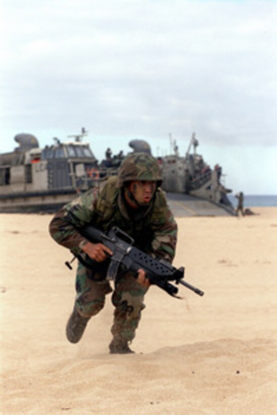 U.S. Marine Lance Cpl. Donald Retreage advances on the beach at Barking Sands, Kauai, during an amphibious assault in support of Exercise RIMPAC '98 on July 31, 1998. RIMPAC '98 is a multinational exercise held on and in waters surrounding the Hawaiian islands, involving more than 25,000 people, 50 ships and 200 aircraft from Australia, Canada, Chile, Japan, the Republic of Korea, and the U.S. Retreage is from New Orleans, La. 