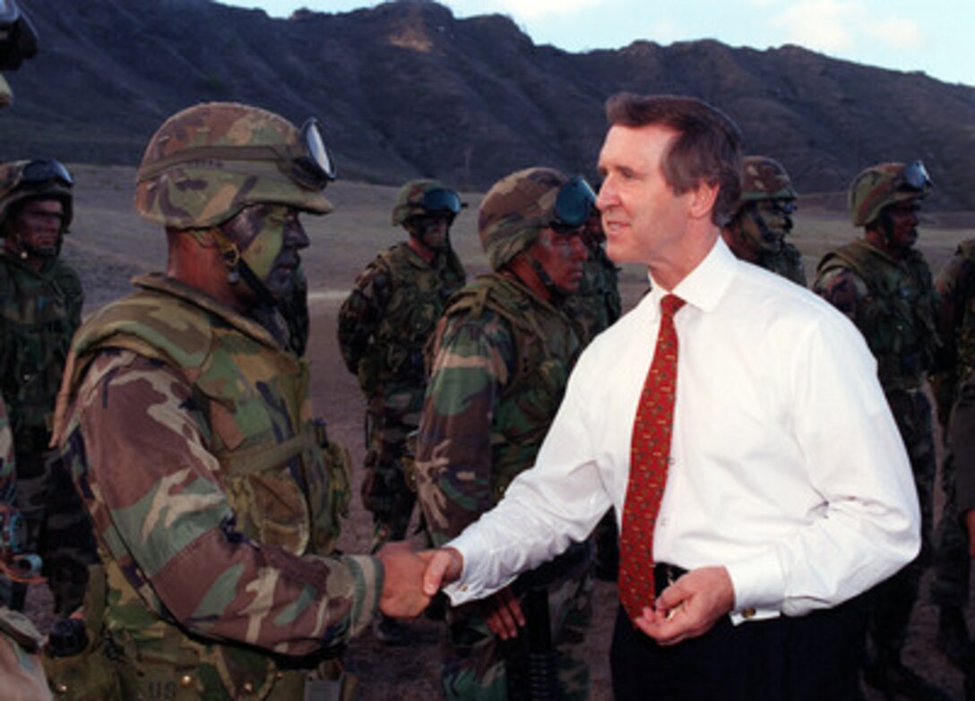 Secretary of Defense William Cohen greets Marines of the 3rd Marine Brigade on the training range at Ulupau Crater, Marine Corps Base Hawaii, Kaneohe on Oct. 30, 1998. Minutes earlier, Cohen watched as these men fast roped from a hovering helicopter and quickly deployed across the range to attack a simulated enemy objective using live fire. 