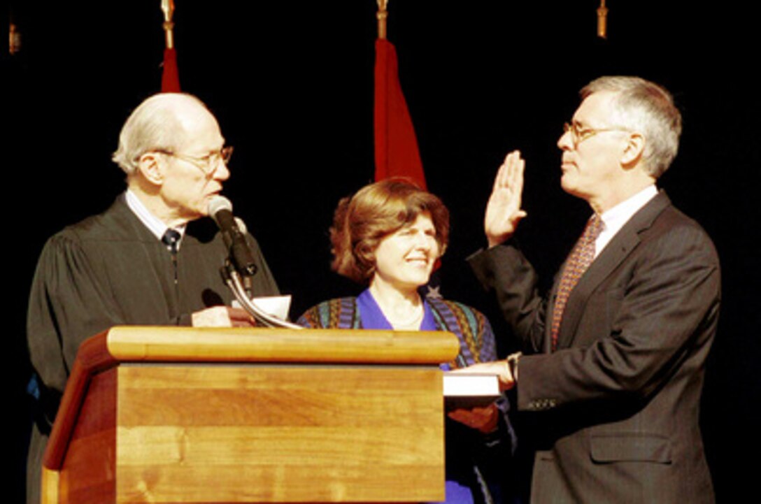 The Honorable Byron R. White (left), associate justice United States Supreme Court, administers the oath of office to Richard J. Danzig (right) as the 71st Secretary of the Navy, while his wife Andrea Danzig (center) holds the bible during a ceremony at the Pentagon on Nov. 16, 1998. 