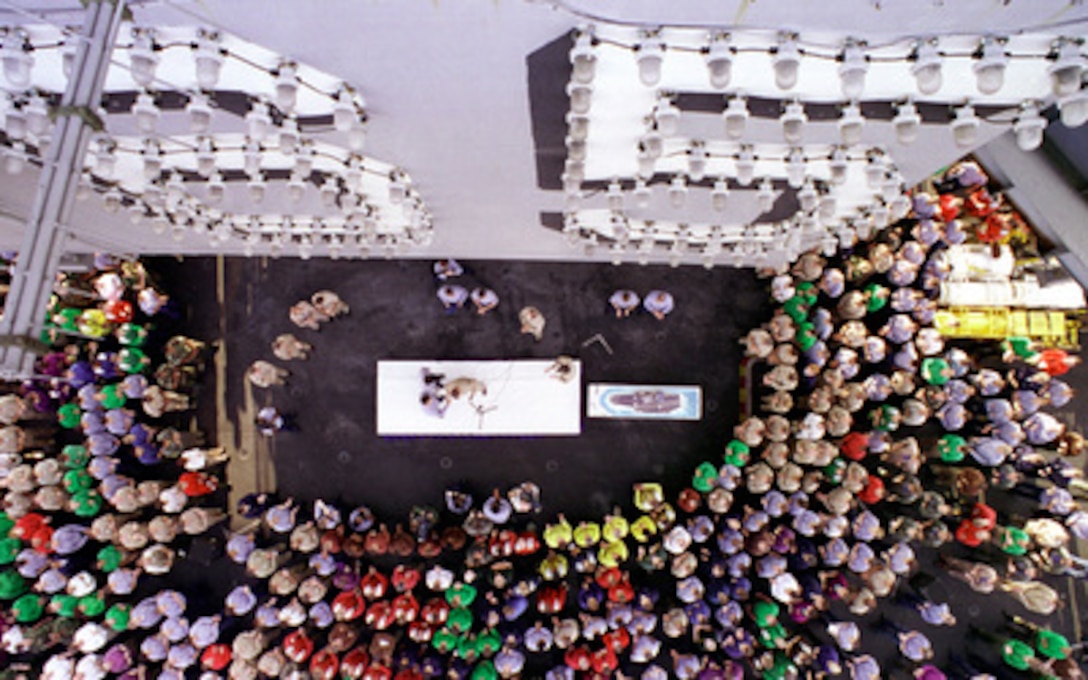 A rainbow of sailors in colored flight deck jerseys and uniform shirts gathers around the Chief of Naval Operations Adm. Jay Johnson as he addresses the crew of the USS Enterprise (CVN 65) during his visit to the aircraft carrier as it operates in the Persian Gulf on Nov. 24, 1998. Enterprise and its embarked Carrier Air Wing 3 are on station in the Persian Gulf in support of Operation Southern Watch, which is the U.S. and coalition enforcement of the no-fly-zone over Southern Iraq. 