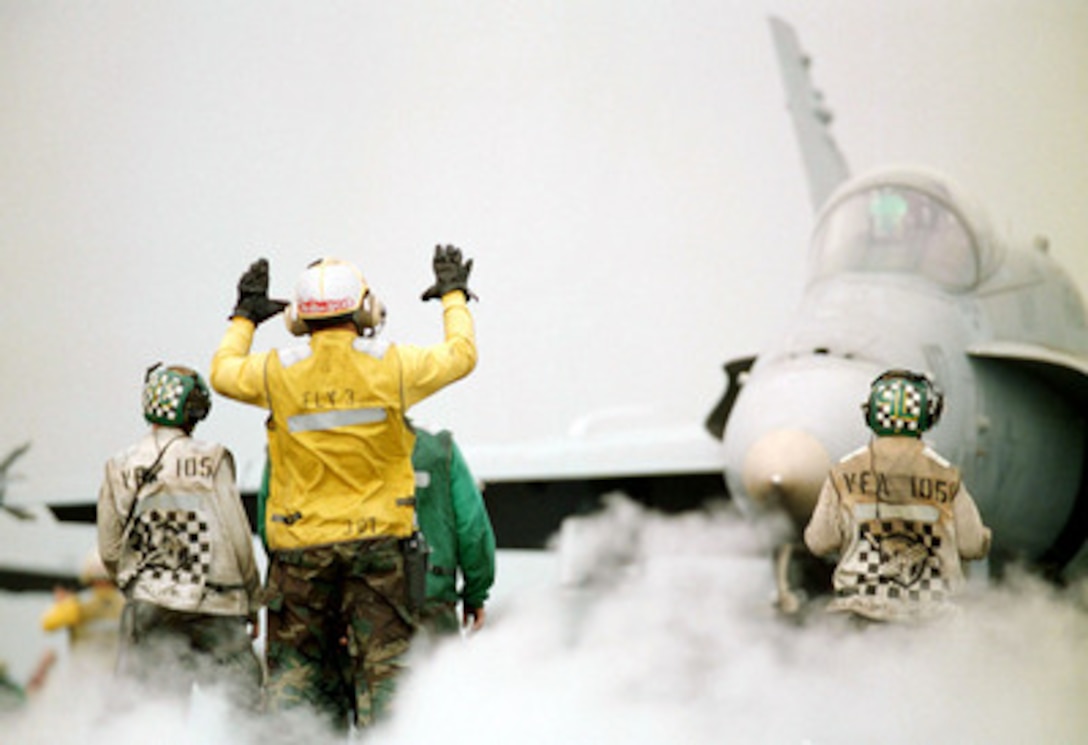 A yellow-shirted plane director guides a U.S. Navy F/A 18 Hornet onto Catapult Four in preparation for launching off the flight deck of the USS Enterprise (CVN 65) as the aircraft carrier operates in the Persian Gulf on Dec. 1, 1998. Enterprise and its embarked Carrier Air Wing 3 are on station in the Persian Gulf in support of Operation Southern Watch, which is the U.S. and coalition enforcement of the no-fly-zone over Southern Iraq. The Hornet belongs to Strike Fighter Squadron 105, Naval Air Station Cecil Field, Fla. 