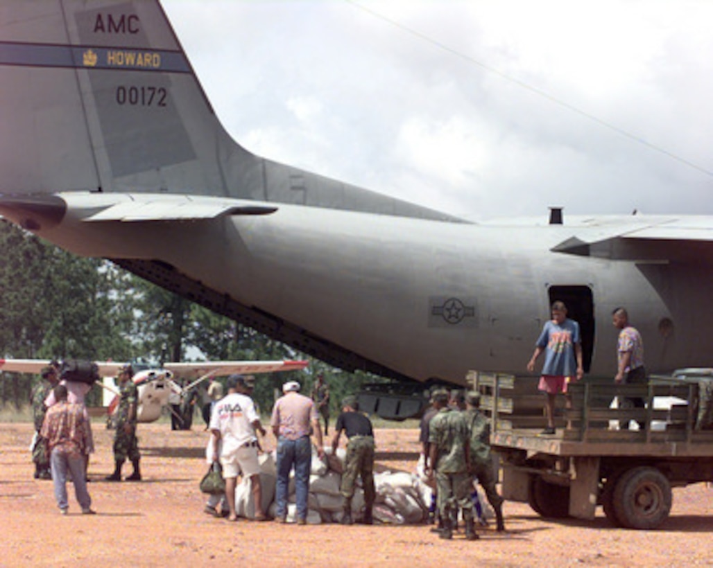 Members of the Honduran military and civilian volunteers help sort a pile of disaster relief supplies unloaded from a U.S. Air Force C-27 Spartan at a dirt airstrip in Mocoron, Honduras, on Nov. 20, 1998. Over 1,800 U.S. service members are helping to rush food, shelter, pure water and medical aid to the central Americans made homeless by Hurricane Mitch. The Spartan is attached to the 310th Airlift Squadron, Howard Air Force Base, Panama. 