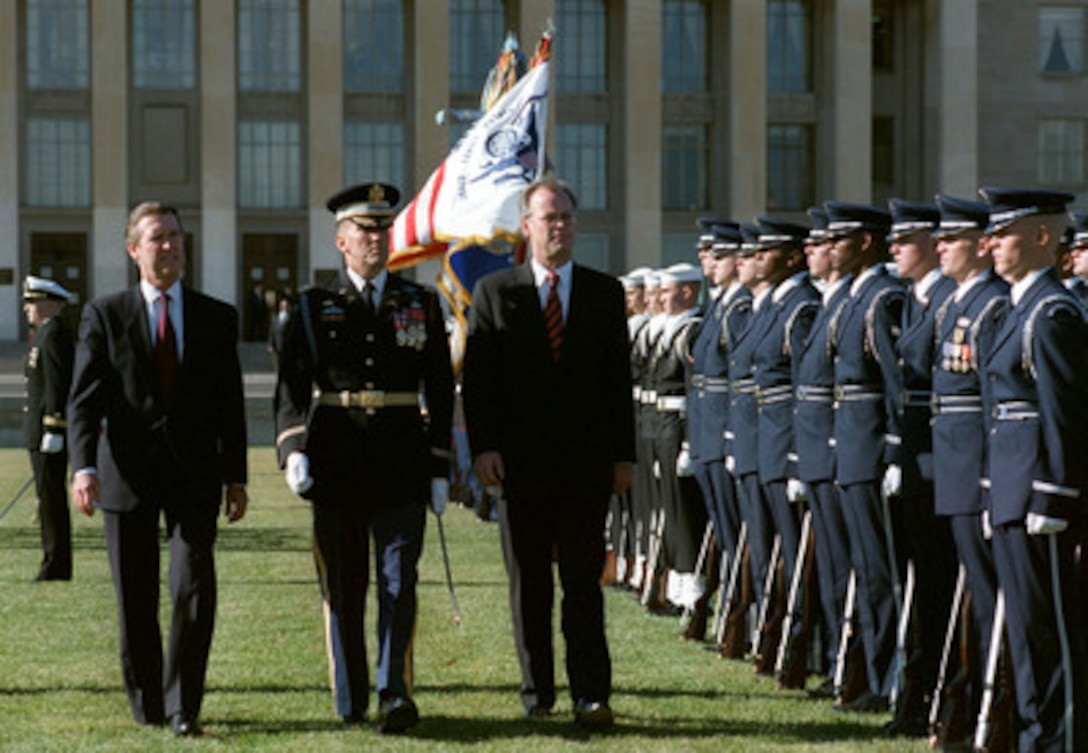 Secretary of Defense William Cohen (left) welcomes visiting German Minister of Defense Rudolf Scharping (right) to the Pentagon with a military full honor arrival ceremony, Nov. 24, 1998. The two defense leaders are escorted by Col. Gregory Gardner (center), U.S. Army, the commander of troops for the ceremony. Following the ceremony, Cohen and Scharping will meet to discuss a range of security issues of interest to both nations. 