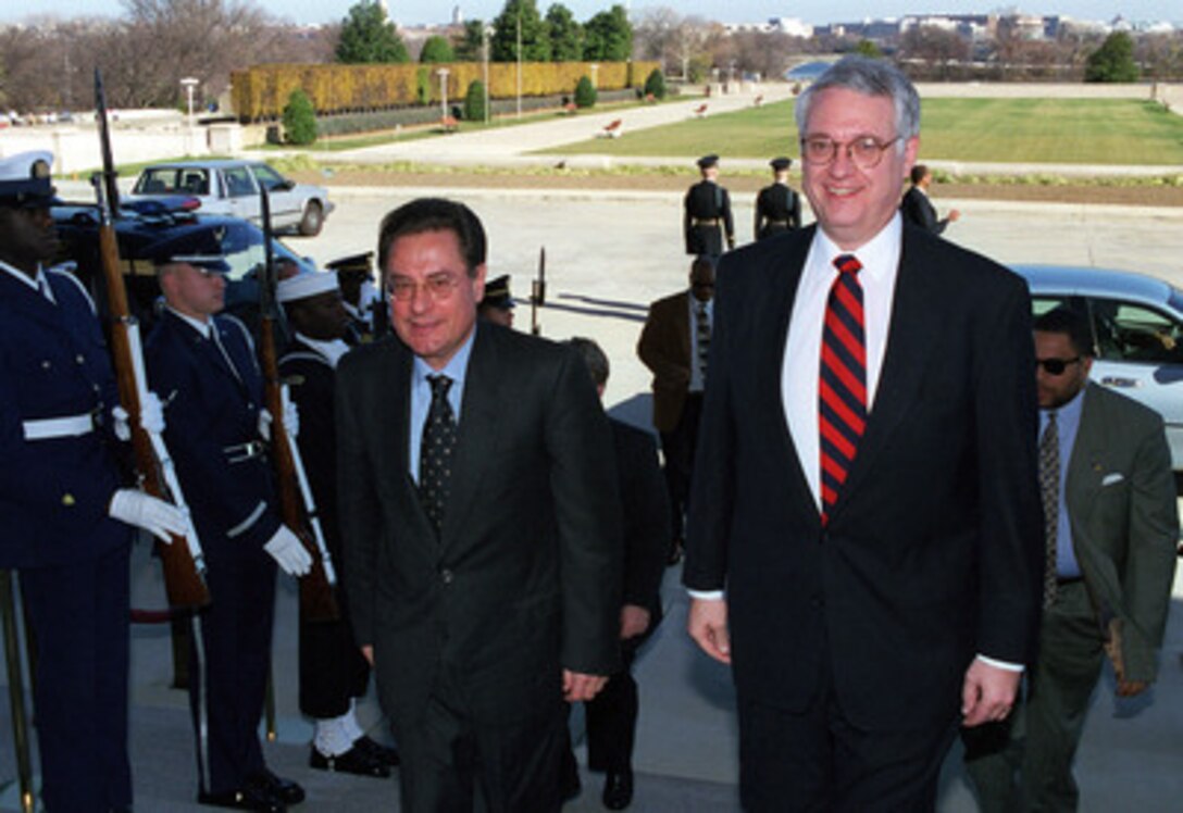 Italian Deputy Minister of Defense Senator Brutti (left) is escorted through an honor cordon by Deputy Secretary of Defense John J. Hamre (right) as he arrives at the Pentagon on Dec. 1, 1998, for meetings with Hamre. 