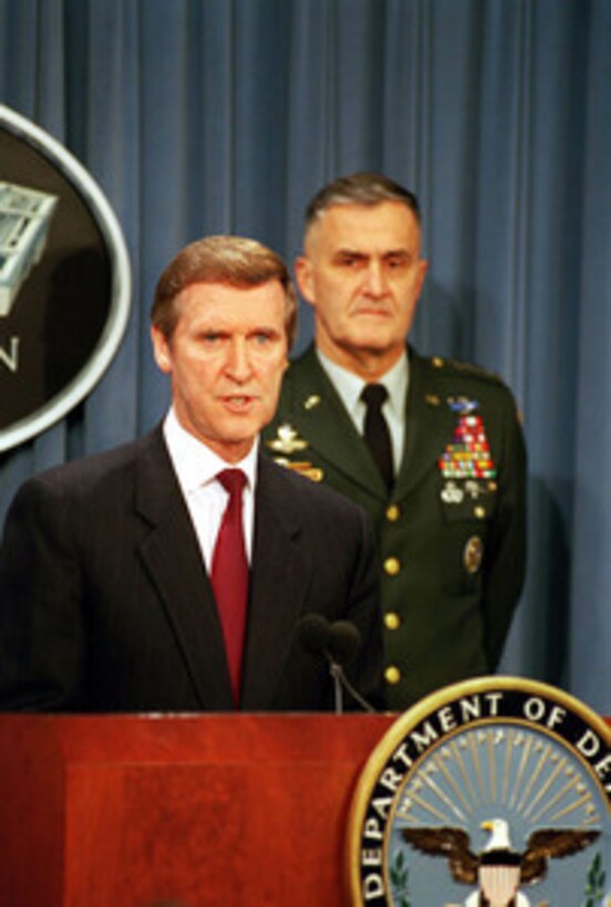 Secretary of Defense William S. Cohen (left) answers a reporter's question as Chairman of the Joint Chiefs of Staff Gen. Henry H. Shelton (right), U.S. Army, listens at a Dec. 16, 1998, Pentagon press briefing on the attack of selected targets in Iraq as part of Operation Desert Fox. 