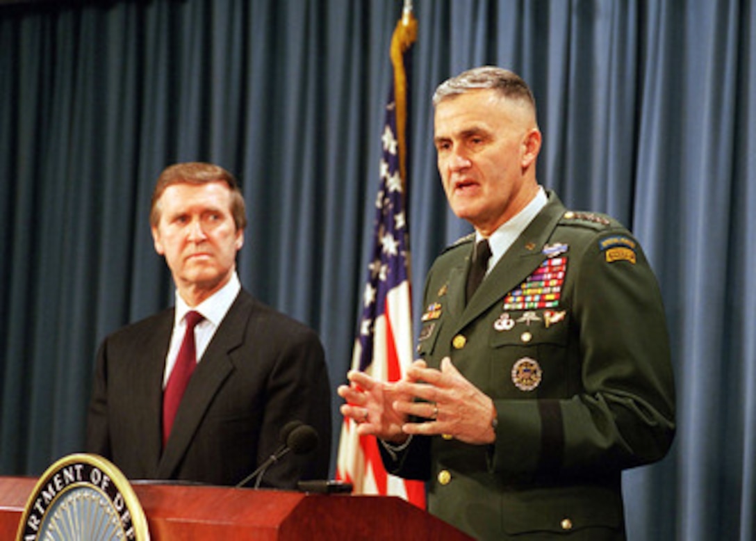 Secretary of Defense William S. Cohen (left) listens as Chairman of the Joint Chiefs of Staff Gen. Henry H. Shelton (right), U.S. Army, answers a reporter's question at a Dec. 16, 1998, Pentagon press briefing on the attack of selected targets in Iraq as part of Operation Desert Fox. 