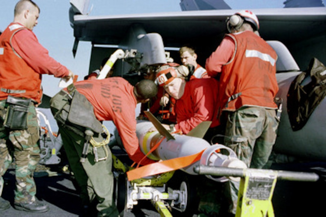 Aviation ordnancemen load an F/A-18 Hornet with a GBU-16 laser guided bomb on flight deck of the aircraft carrier USS Enterprise (CVN 65) on Dec. 17, 1998, in preparation for a second wave of attacks against Iraq during Operation Desert Fox. Enterprise and its embarked Carrier Air Wing 3 are operating in the Persian Gulf in support of Desert Fox. 