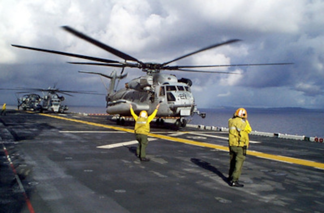 A Navy Landing Signal Enlisted signals a U.S. Marine Corps CH-53 Super Stallion helicopter to lift off from the amphibious assault ship USS Wasp (LHD 1) on Jan. 17, 1998, during Joint Task Force Exercise 98-1. More than 30,000 U.S. military personnel are participating in the exercise which is testing joint forces on their ability to deploy rapidly and conduct joint operations during a crisis. All branches of the armed forces are training side-by-side using the latest advances in technology in a simulated high-threat environment that involves air, naval and ground operations. 