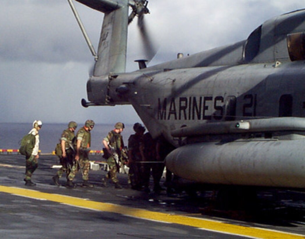 U.S. Marines from the 26th Marine Expeditionary Unit load into a CH-53 Super Stallion helicopter on the flight deck of the amphibious assault ship USS Wasp (LHD 1) on Jan. 17, 1998, during Joint Task Force Exercise 98-1. More than 30,000 U.S. military personnel are participating in the exercise which is testing joint forces on their ability to deploy rapidly and conduct joint operations during a crisis. All branches of the armed forces are training side-by-side using the latest advances in technology in a simulated high-threat environment that involves air, naval and ground operations. 