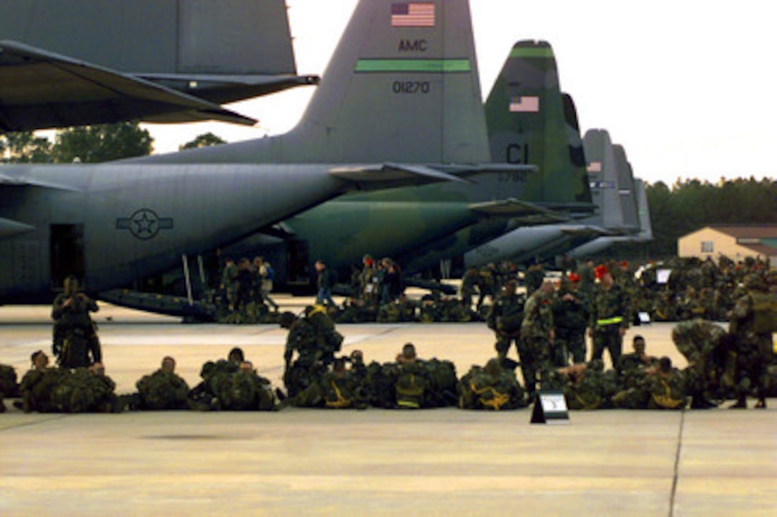 Soldiers from the U.S. Army's 82nd Airborne Division wait to load into U.S. Air Force C-130 Hercules aircraft at Pope Air Force Base, N.C., on Jan. 29, 1998. Nearly 80 aircraft will airdrop almost 3,000 personnel and their equipment into a Fort Bragg landing zone in one of the largest airborne operations since World War II as part of Joint Task Force Exercise 98-1. More than 30,000 U.S. military personnel are participating in the exercise which is testing joint forces on their ability to deploy rapidly and conduct joint operations during a crisis. All branches of the armed forces are training side-by-side using the latest advances in technology in a simulated high-threat environment that involves air, naval and ground operations. 