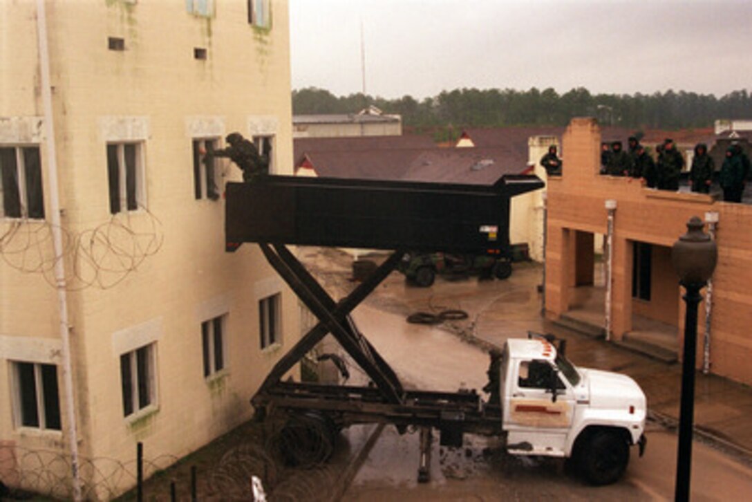 U.S. Marines use a truck lift to enter the second story of a building in the Military Operations in Urban Terrain facility in a at Camp Lejeune, N.C. on Jan. 23, 1998, during Urban Warrior. Urban Warrior is the U.S. Marine Corps Warfighting Laboratory's series of limited objective experiments examining new urban tactics and experimental technologies. The experiment is being conducted by the Special Purpose Marine Air-Ground Task Force (Experimental) from Quantico, Va., and Charlie Company, 1st Battalion, 6th Marines from Camp Lejeune, with support from the 2nd Marine Expeditionary Force. 