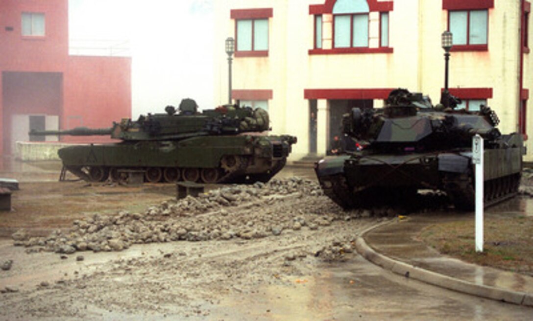 M-1A1 Abrams tanks patrol the streets at the Military Operations in Urban Terrain facility at Camp Lejeune, N.C. on Jan. 23, 1998, during Urban Warrior. Urban Warrior is the U.S. Marine Corps Warfighting Laboratory's series of limited objective experiments examining new urban tactics and experimental technologies. The experiment is being conducted by the Special Purpose Marine Air-Ground Task Force (Experimental) from Quantico, Va., and Charlie Company, 1st Battalion, 6th Marines from Camp Lejeune, with support from the 2nd Marine Expeditionary Force. 
