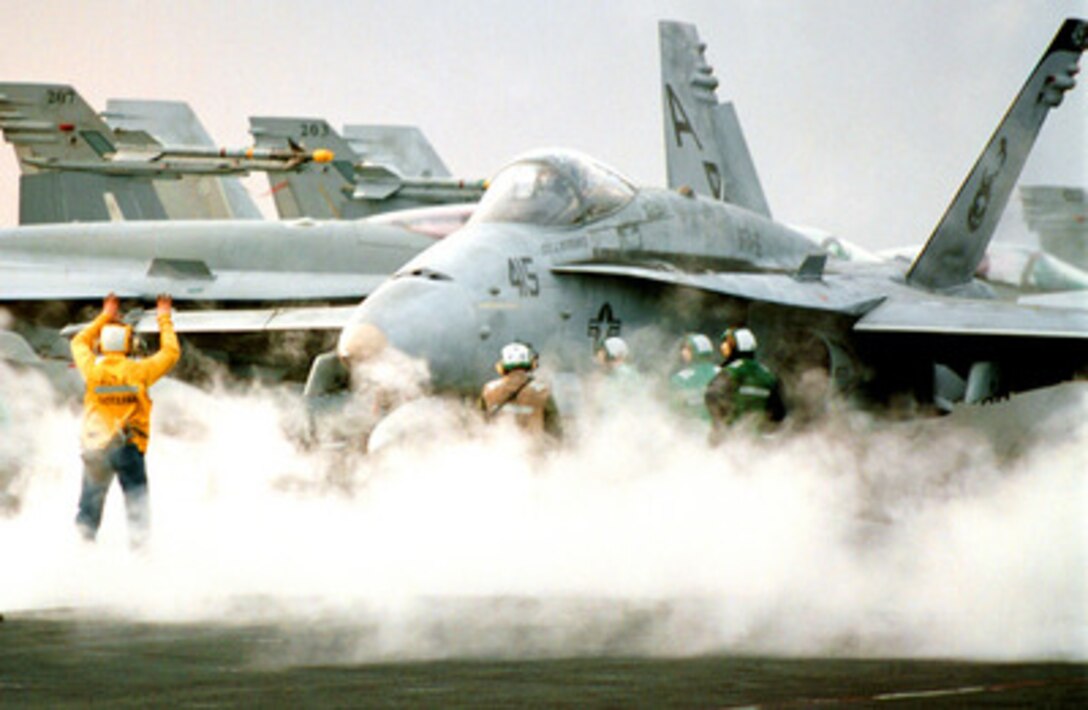 Flight deck crewmen are surrounded by catapult steam as they ready an F/A-18C Hornet for launch from the deck of the aircraft carrier USS George Washington (CVN 73) as the ship steams in the Persian Gulf on Jan. 28, 1998. The Washington battle group is operating in the Persian Gulf in support of Operation Southern Watch which is the U.S. and coalition enforcement of the no-fly-zone over Southern Iraq. The Hornet is from Fighter Attack Squadron 86, Naval Air Station Cecil Field, Fla. 