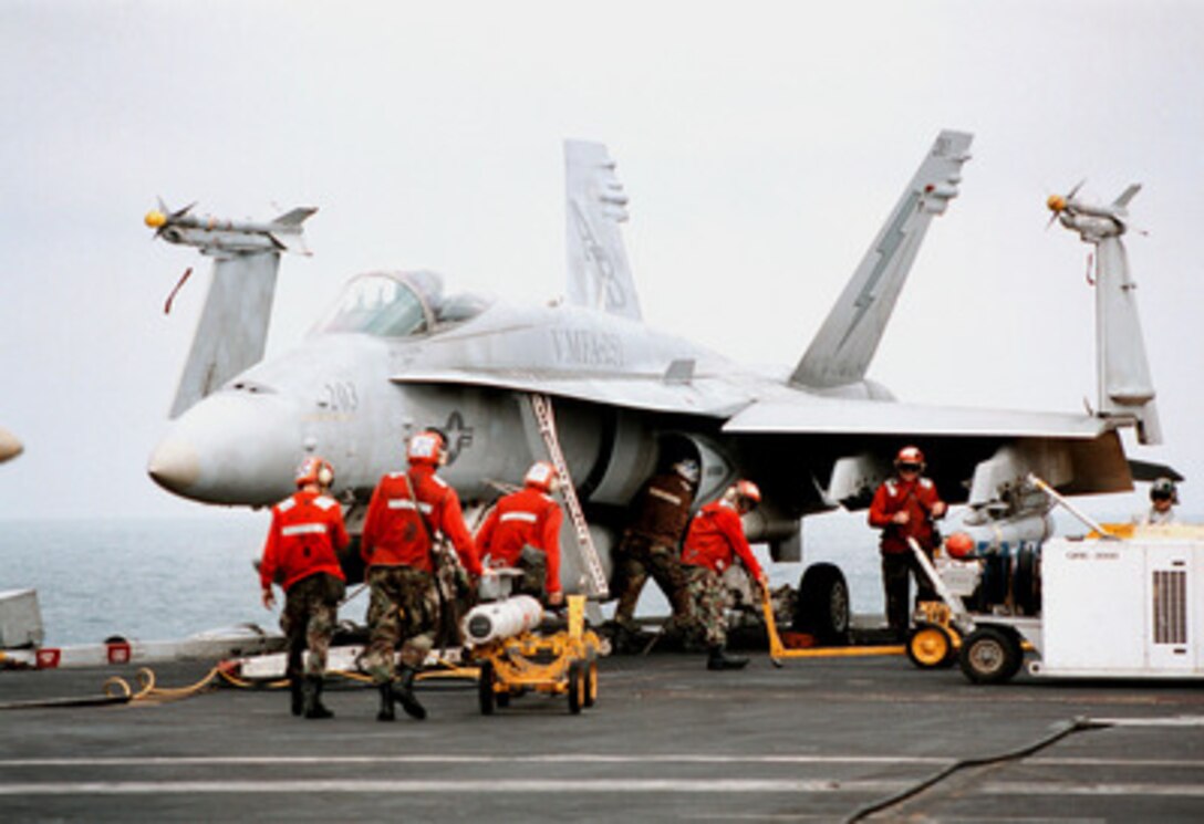 Aviation ordnancemen from Marine Fighter Attack Squadron 251 load missiles onto an F/A-18C Hornet on the flight deck of the aircraft carrier USS George Washington (CVN 73) as the ship steams in the Persian Gulf on Jan. 29, 1998. The Washington battle group is operating in the Persian Gulf in support of Operation Southern Watch which is the U.S. and coalition enforcement of the no-fly-zone over Southern Iraq. 