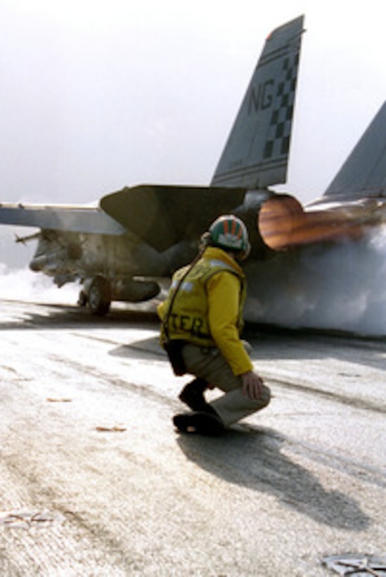 U.S. Navy Lt. Rick Krystof watches an F-14 Tomcat hurtle down the catapult of the aircraft carrier USS Nimitz (CVN 68) on Jan. 29, 1998. The Nimitz battle group is operating in the Persian Gulf in support of Operation Southern Watch which is the U.S. and coalition enforcement of the no-fly-zone over Southern Iraq. Krystof is from Westford, Mass. 