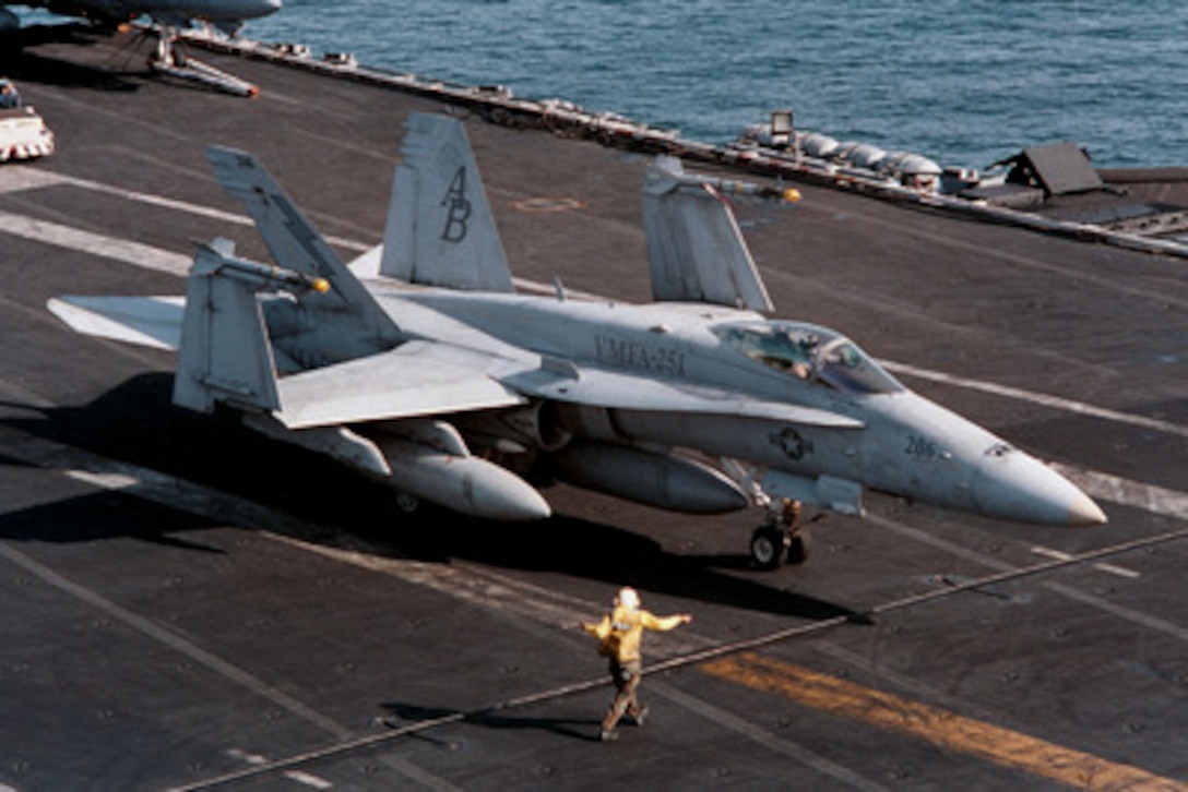 An F/A-18C Hornet from Marine Fighter Attack Squadron 251 is directed to the catapult in preparation for launch from the deck of the aircraft carrier USS George Washington (CVN 73 as the ship steams in the Persian Gulf on Jan. 30, 1998. The Washington battle group is operating in the Persian Gulf in support of Operation Southern Watch which is the U.S. and coalition enforcement of the no-fly-zone over Southern Iraq. Marine Fighter Attack Squadron 251 is deployed to the Washington from Marine Corps Air Station Beaufort. S.C. 