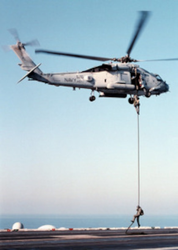 Members of the USS George Washington (CVN 73) Explosive Ordnance Disposal team practice for a rapid insertion as they slide from an SH-60B Seahawk helicopter during a fast rope training exercise as the ship steams in the Persian Gulf on Feb. 6, 1998. The Washington battle group is operating in the Persian Gulf in support of Operation Southern Watch which is the U.S. and coalition enforcement of the no-fly-zone over Southern Iraq. 