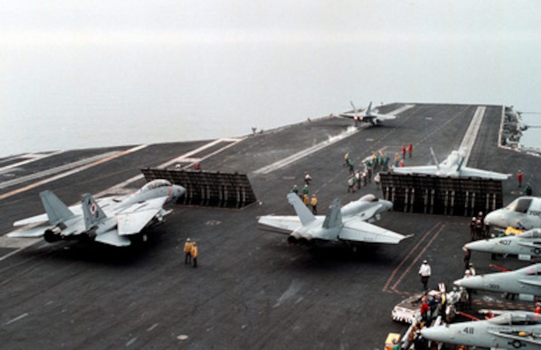 An F/A-18 Hornet hurtles down the No. 2 catapult while an F-14 Tomcat (left) and other Hornets line up for the next launch cycle on the USS George Washington (CVN 73) as the ship steams in the Persian Gulf on Feb. 7, 1998. The Washington battle group is operating in the Persian Gulf in support of Operation Southern Watch which is the U.S. and coalition enforcement of the no-fly-zone over Southern Iraq. 