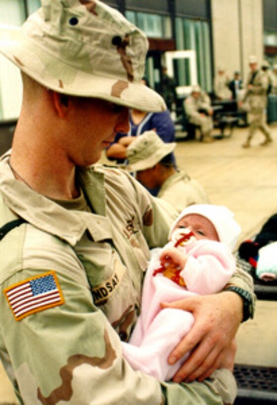 Pvt. Michael Lindsay says good-bye to his daughter Mikayla at the Kelly Hill Recreation Center, Fort Benning, Ga., before flying to Kuwait on Jan 20, 1998. Lindsay is one of approximately 1,500 U.S. Army soldiers participating with members of the Kuwaiti armed forces in Exercise Intrinsic Action 98-1. The exercise is intended to strengthen military-to-military relationships, improve readiness and interoperability between U.S. and Kuwaiti armed forces, and to enhance U.S. military force capabilities to deploy quickly to the region. 