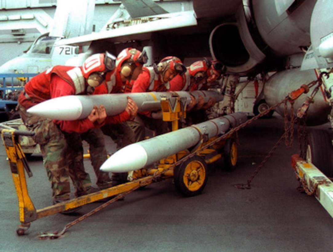 A team of aviation ordnancemen cradle an AIM-7 Sparrow medium range air-to-air missile as they load onto an F/A-18 Hornet on the flight deck of the USS Independence (CV 62) while the ship operates in the Persian Gulf on Feb. 7, 1998. Independence and its embarked Carrier Air Wing 5 are on station in the Persian Gulf in support of Operation Southern Watch which is the U.S. and coalition enforcement of the no-fly-zone over Southern Iraq. 