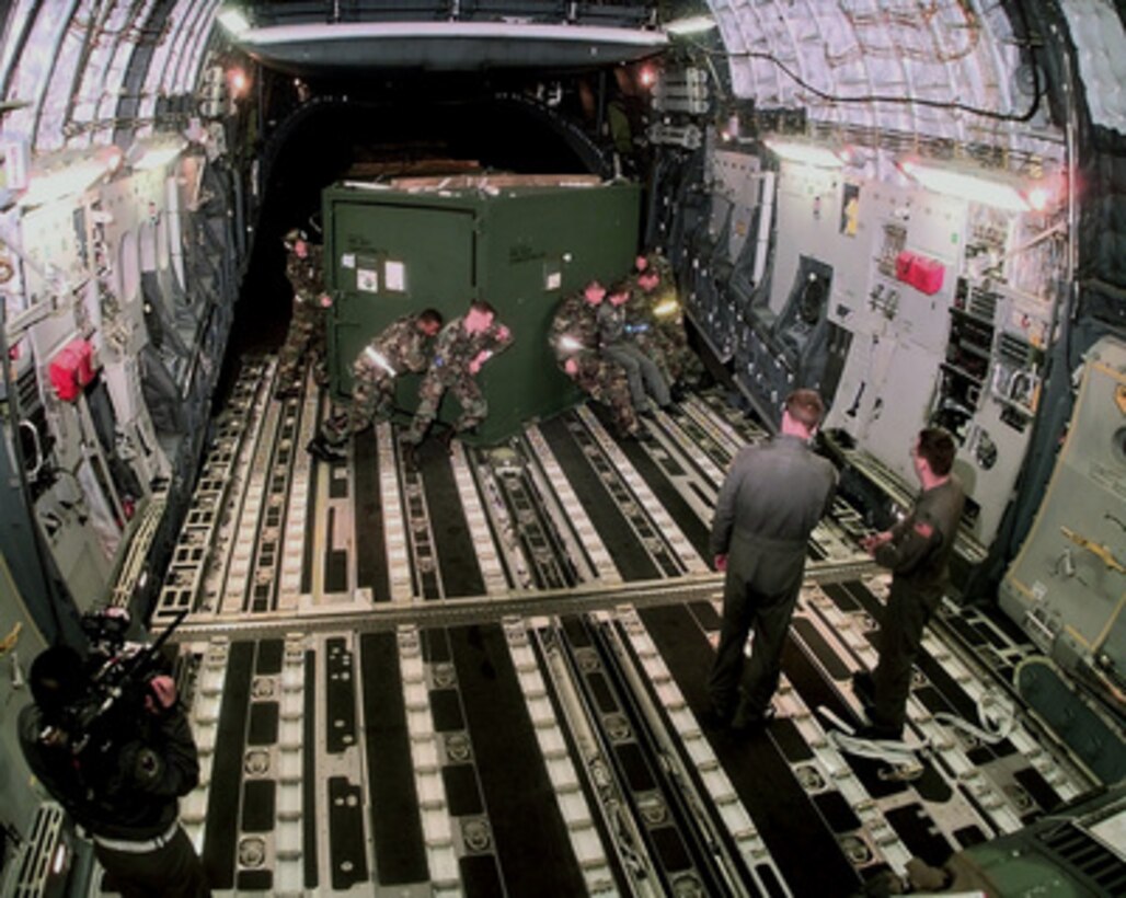 Personnel of the 437th Aerial Port Squadron use muscle power to turn an equipment container into position in a C-17A Globemaster III at Charleston Air Force Base, S.C., on Feb. 8, 1998. The Globemaster is air-lifting personnel, equipment and vehicles of the 437th Civil Engineer Squadron, Fire Department, and Explosive Ordnance Disposal Unit, from Charleston to the Persian Gulf region. 