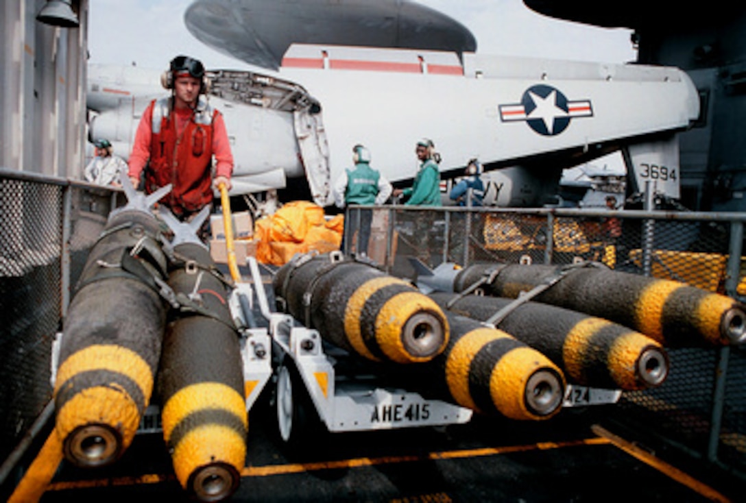 Petty Officer 3rd Class William Bailey Jr. transports MK-82 500-pound bombs from a weapons elevator to the flight deck aboard the aircraft carrier USS George Washington (CVN 73 as the ship steams in the Persian Gulf on Feb. 10, 1998. The Washington battle group is operating in the Persian Gulf in support of Operation Southern Watch which is the U.S. and coalition enforcement of the no-fly-zone over Southern Iraq. Bailey is a Navy aviation ordnanceman from Louisburg, N.C. 