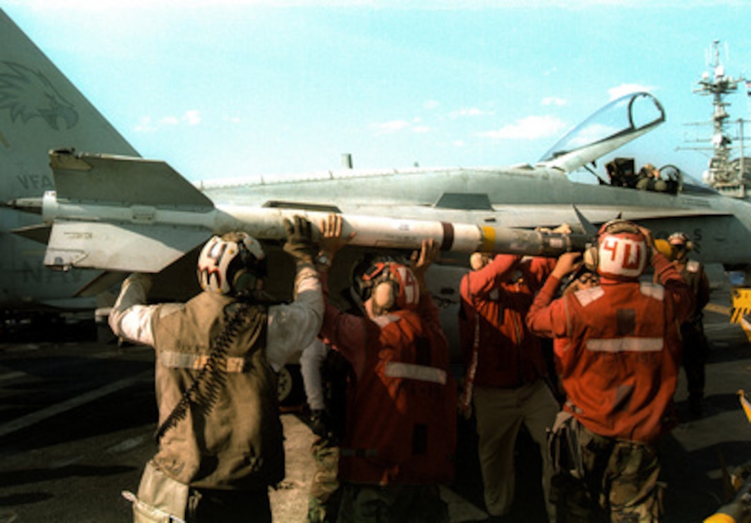 Aviation ordnancemen load an AIM-9 Sidewinder short range missile on an F/A-18 Hornet on the flight deck of the USS Independence (CV 62) while the ship operates in the Persian Gulf on Feb. 10, 1998. Independence and its embarked Carrier Air Wing 5 are on station in the Persian Gulf in support of Operation Southern Watch which is the U.S. and coalition enforcement of the no-fly-zone over Southern Iraq. 