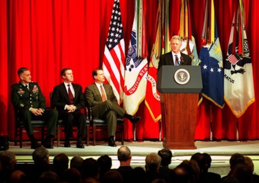 President Bill Clinton addresses an audience of military personnel and civilian Department of Defense employees at the Pentagon on Feb. 17, 1998. The internationally televised speech, in part a warning to Saddam Hussein, was in essence an explanation to the American people of why military action may be required against Iraq. Listening to the address from the stage are Chairman of the Joint Chiefs of Staff Gen. Henry H. Shelton (left), U.S. Army; Secretary of Defense William S. Cohen (center) and Vice President Al Gore (right). 