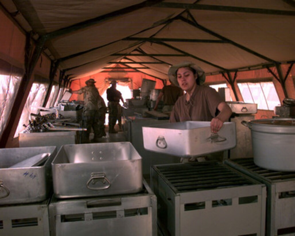 Senior Airman Sharon King, a senior cook with the 319th Services Squadron, helps to set up a field kitchen at an operating base in Southwest Asia on Feb. 17, 1998. The kitchen will feed over 400 U.S. Air Force personnel currently deployed to the Gulf region as part of an Air Mobility Command Tanker Task Force operating in the Southwest Asia theater in support of Operation Southern Watch. Southern Watch is the U.S. and coalition enforcement of the no-fly-zone over Southern Iraq. The 319th Services Squadron is deployed from Grand Forks, N.D. 